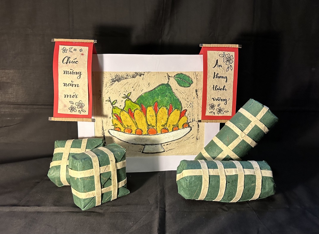 A still life arrangement featuring wrapped packages, vietnamese text and a painted image of food